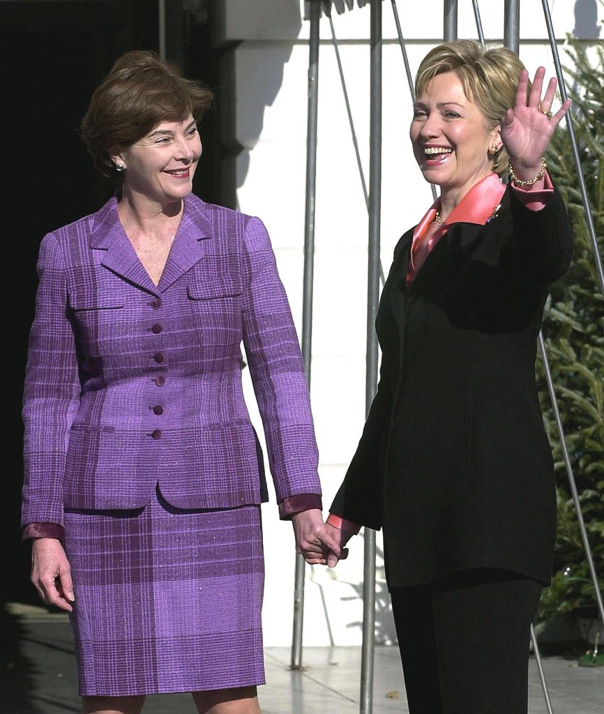 Toen de Bushes er eenmaal waren, liepen Hillary en Laura zelfs hand in hand: