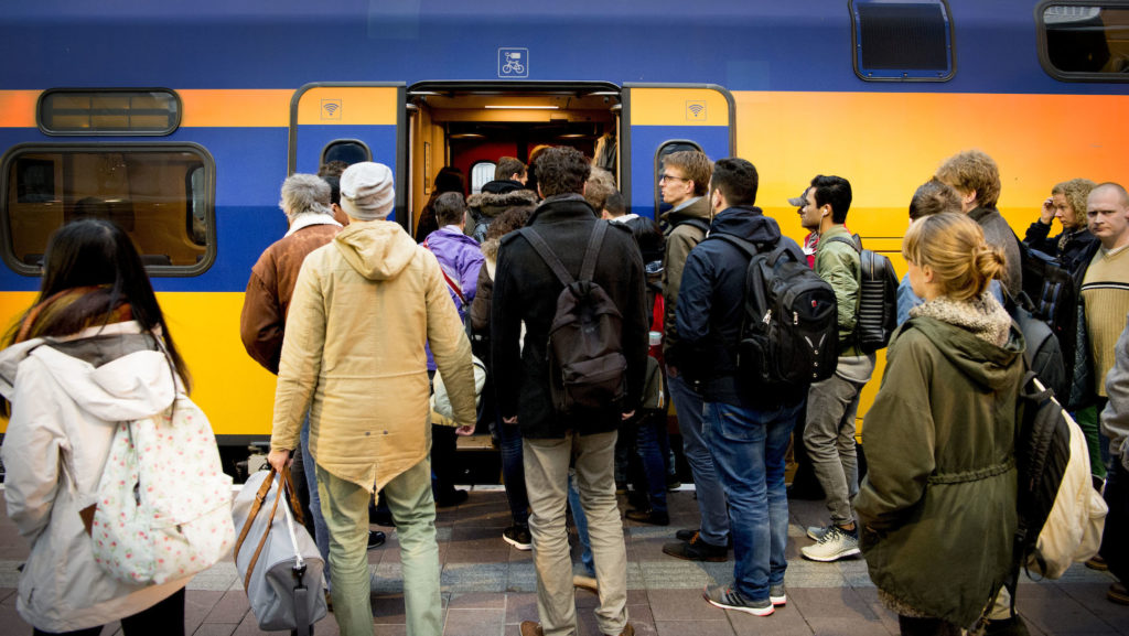 overvolle trein van de NS, reiziger kan niet zitten