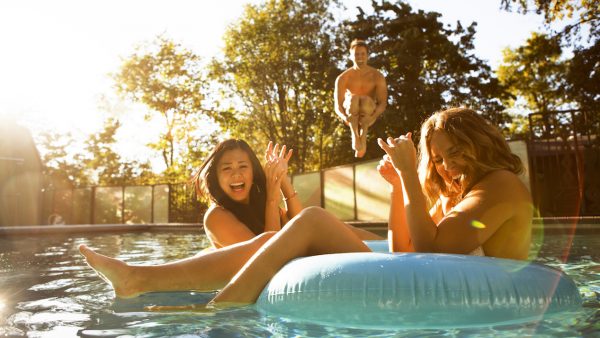 Drie mensen houden een poolparty in de zon