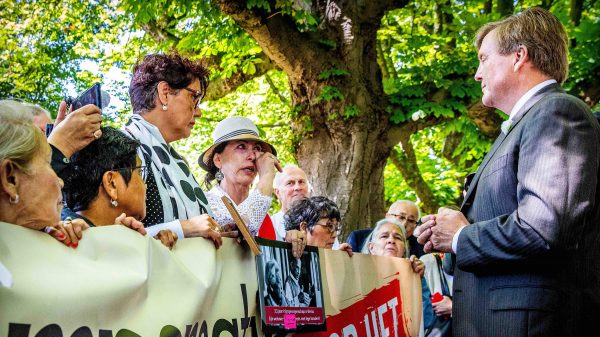 Koning praat met demonstranten na opening museum over Indië