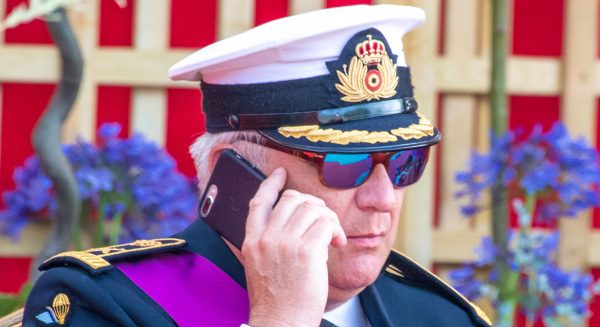 prins laurent druk bezig met telefoon op nationale feestdag parade