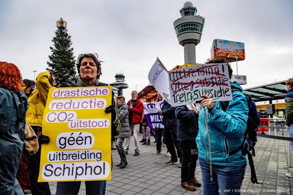 Klimaatactivisten dansen in badkleding op Schiphol