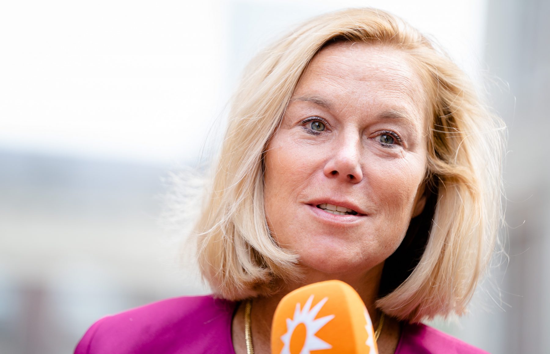 Sigrid Kaag D66 in roze jas met microfoon