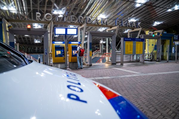 Een politieauto stopt voor station Rotterdam blaak, daar is een man in zijn gezicht geschoten