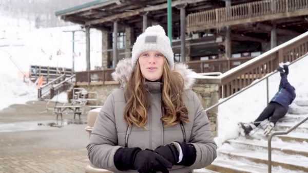 Weerbericht: skiër glibbert door het beeld terwijl weervrouw dolenthousiast verslag doet van de sneeuw