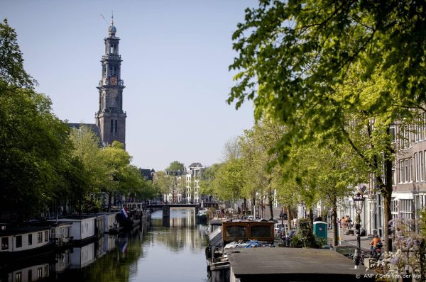 Busje met toeristen rijdt Prinsengracht in Amsterdam in