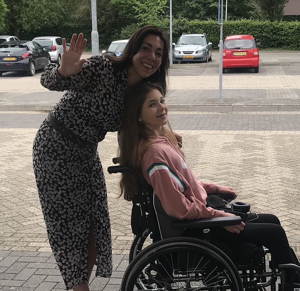 Foto van Suzanne die rolstoel van Kess met dwarslaesie duwt