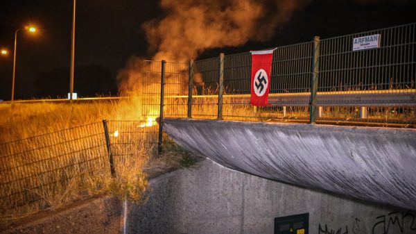 Hakenkruisvlag opgehangen aan een viaduct bij Stroe