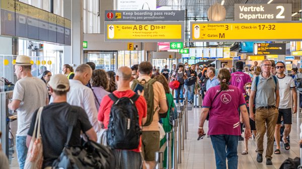 Drukke dag op Schiphol, reizigers krijgen water en stroopwafels