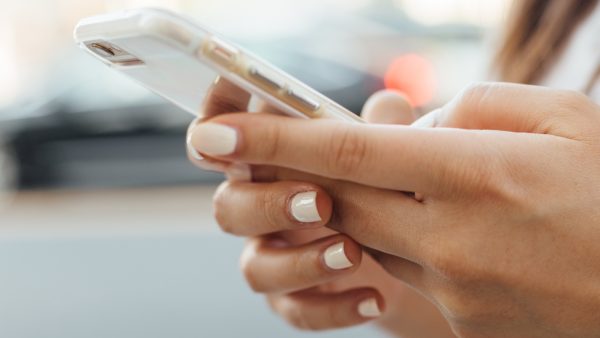 Foto van een vrouw met een telefoon in haar hand