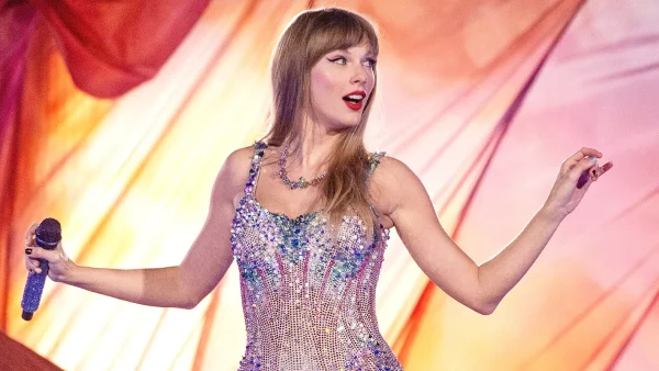 Taylor Swift draagt een roze glitterbody en houdt microfoon vast