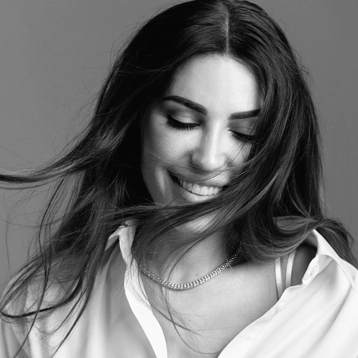 Yolanthe Cabau in zwart wit met een witte blouse en een gouden ketting om