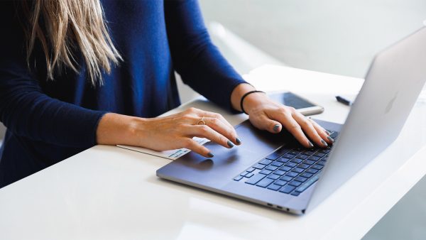 Vrouw in blauw shirt achter een laptop