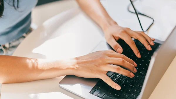 Vrouwenhanden achter een laptop