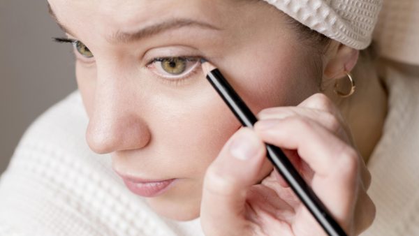 Vrouw die eyeliner aan het zetten is.