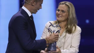 Sabrina Wiegman gehuld in een wit pak, neemt UEFA prijs in ontvangst