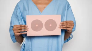 Vrouw met kanker houdt bord met plaatje van borsten voor haar lichaam