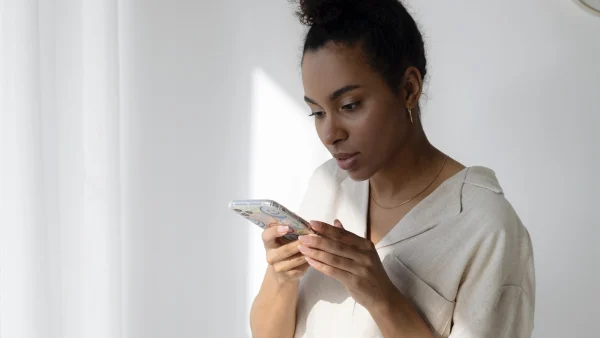 vrouw kijkt op telefoon kriti