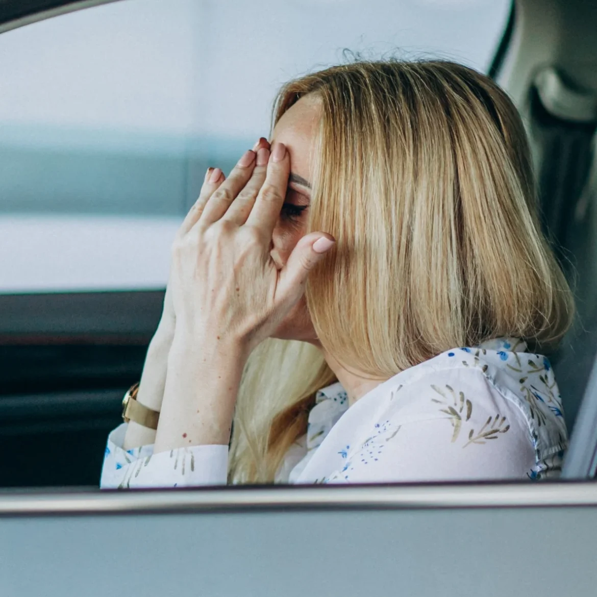Vrouw in haar auto. Baalt van gestolen kentekenplaten