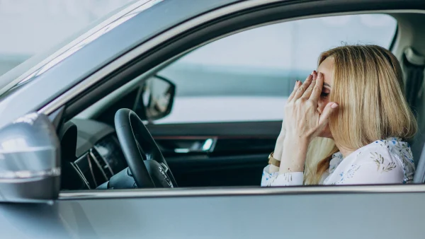 Vrouw in haar auto. Baalt van gestolen kentekenplaten