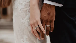 Een bruidspaar houdt elkaars handen vast