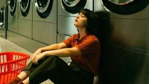 Vrouw zit op de grond tegen wasmachines