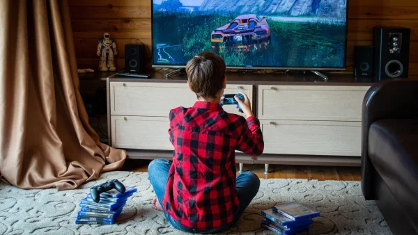 Jongen zit op de grond en speelt videogames.