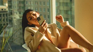 Vrouw zit in stoel met telefoon in hand