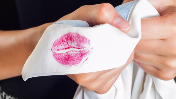 Een vrouw houdt een shirt vast waar een lippenstift print op gedrukt staat