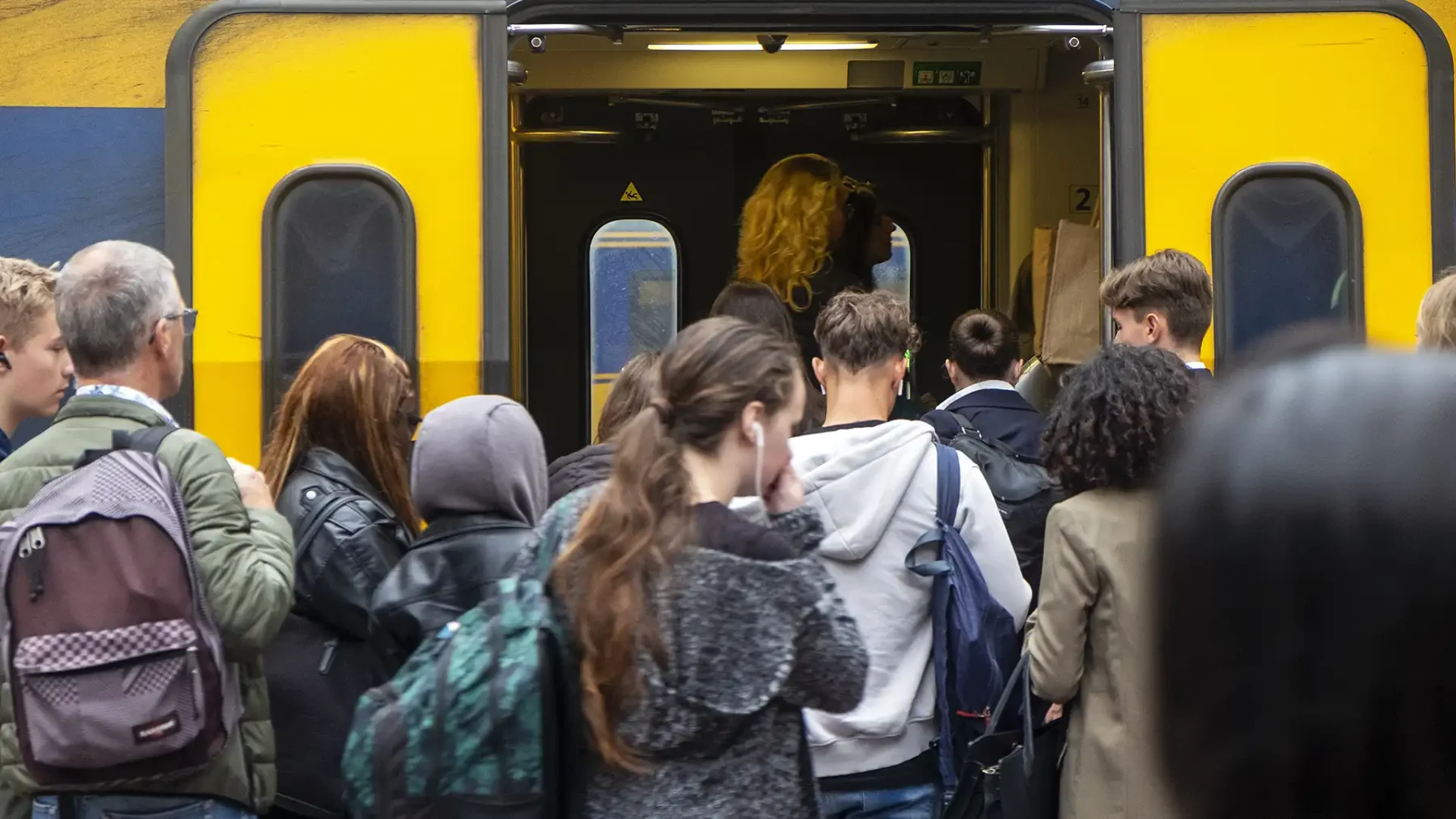 Mensen stappen in en uit een volle trein