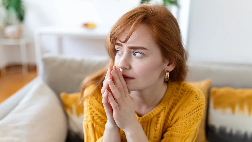 Vrouw, ze heet Alicia, zit op de bank te piekeren