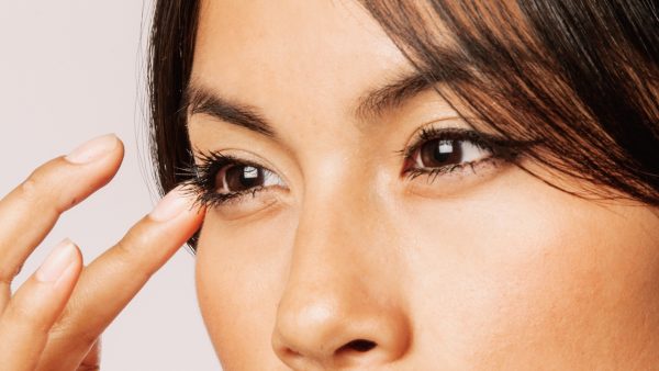 Aziatische vrouw veegt langs haar aangebrachte eyeliner