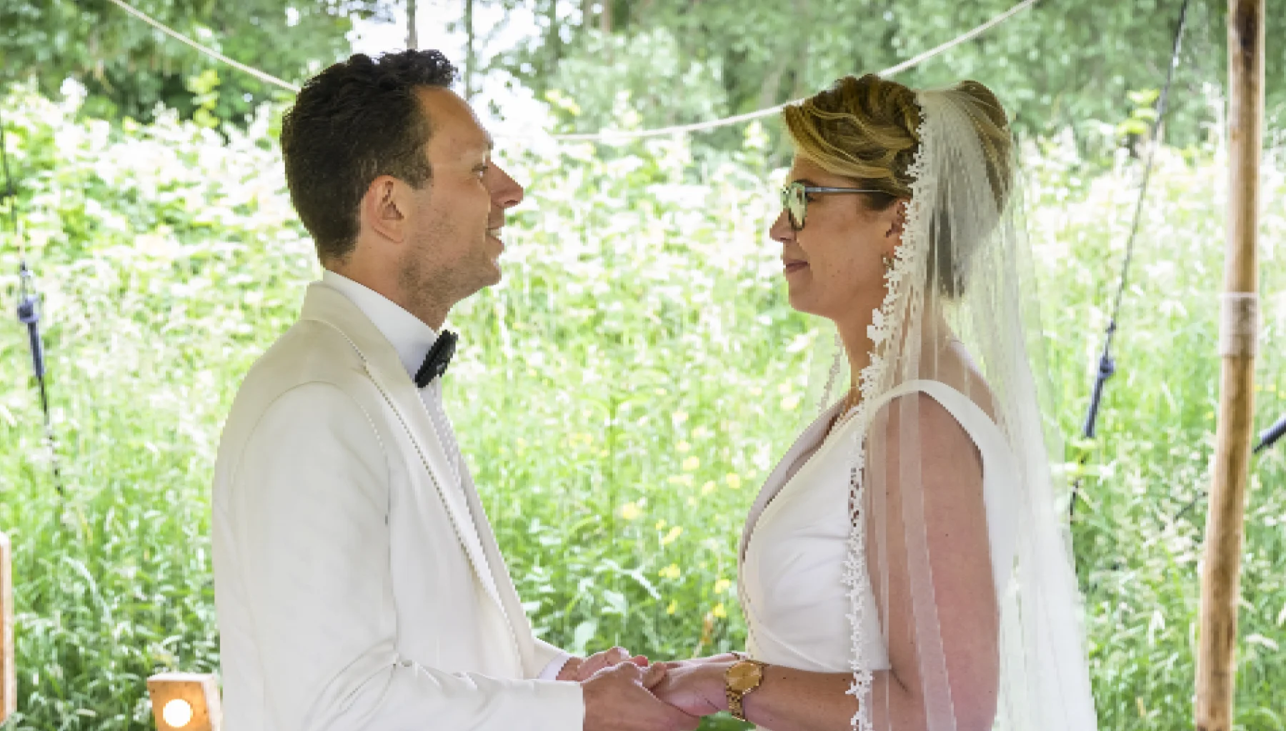 Man en vrouw in bruidskleding in een tuin