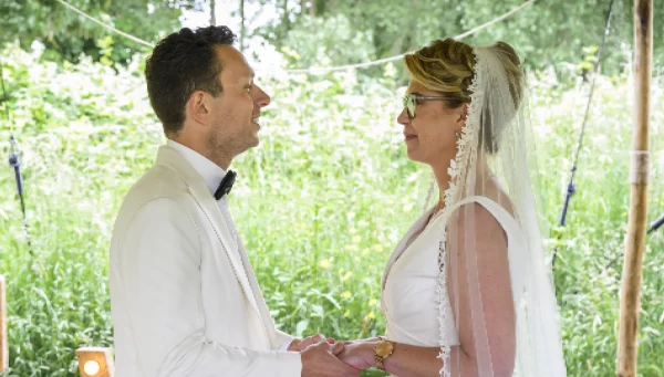 Man en vrouw in bruidskleding in een tuin