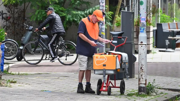 Man in PostNL-kleding bezorgt post