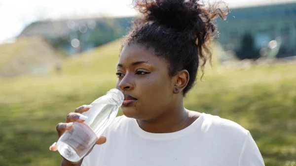 Vrouw drinkt water uit een plastic fles
