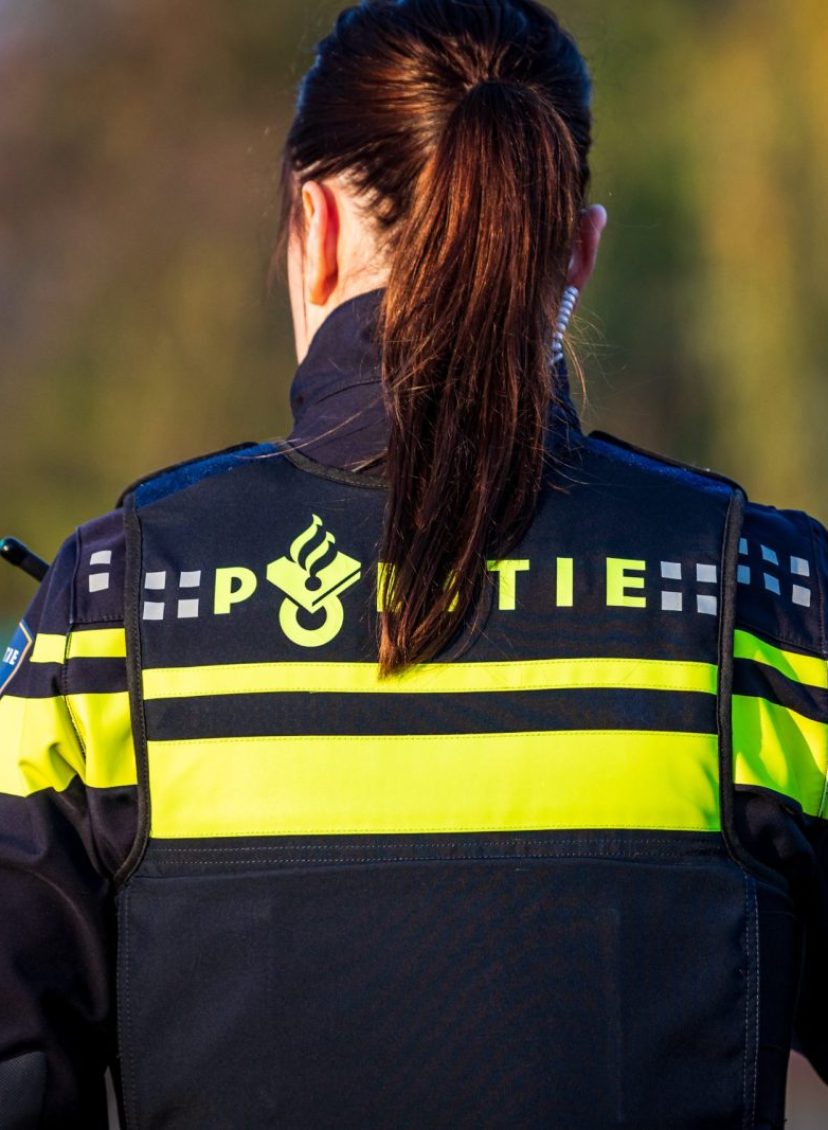 Foto van een vrouw van de politie, gezien vanaf de achterkant