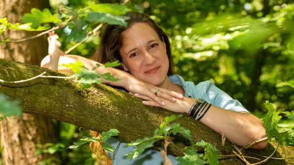 Chantal heeft Psoriasis en leunt op een boomstronk