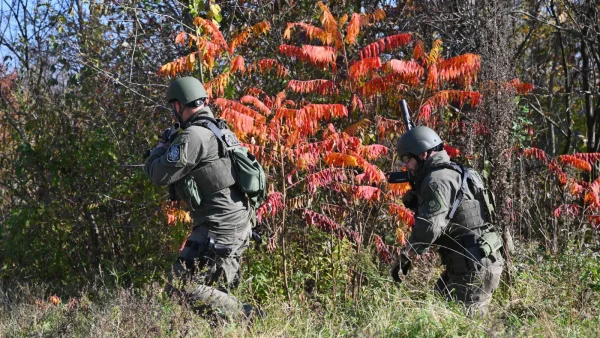 Twee agenten zoeken in het bos naar de verdachte schutter van de schietpartij Lewiston