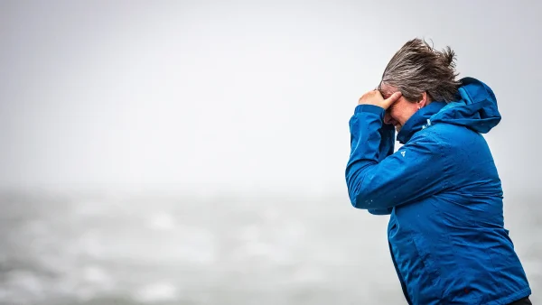 Vrouw loopt door storm Ciarán op het strand in Zeeland