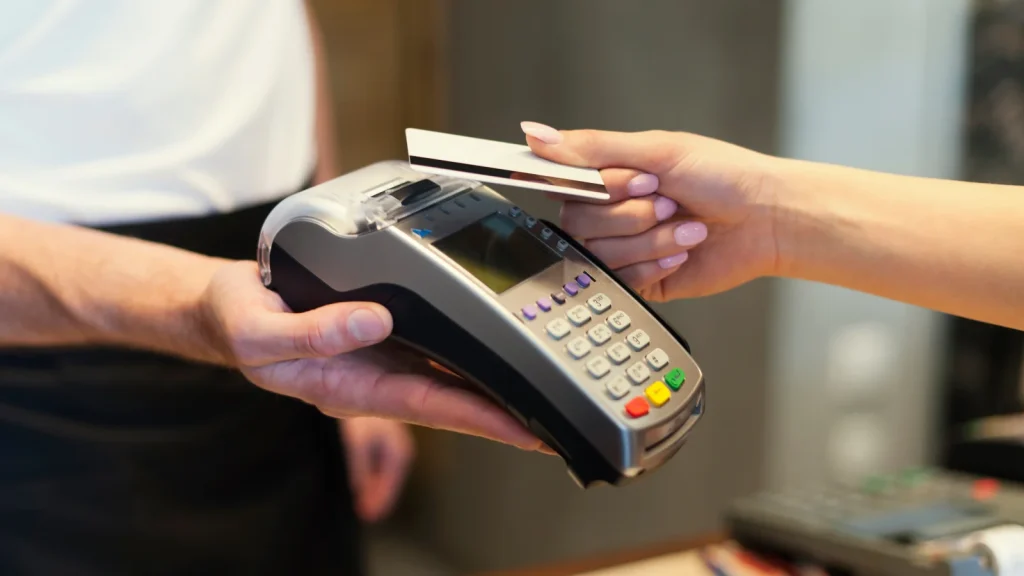 Vrouw legt haar pinpas op een pinautomaat, ze heeft de rekening van haar man leeggehaald tijdens de scheiding