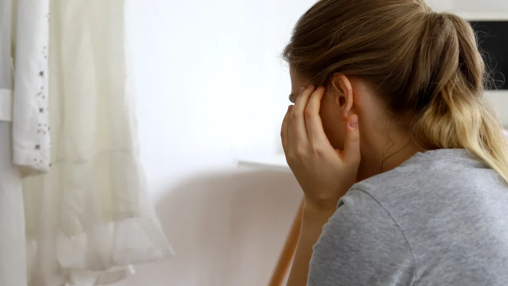 Vrouw houdt handen bij haar oren omdat ze misofonie heeft