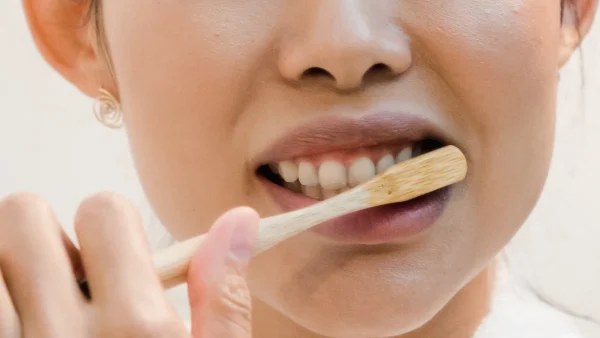 Vrouw is aan het tandenpoetsen voor of na het ontbijt