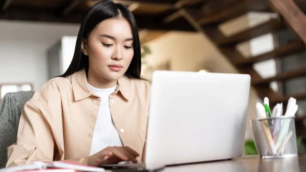 Vrouw zit achter de laptop voor het overstappen van zorgverzekering