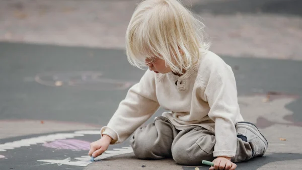 Kind tekent met stoepkrijt. Selectief mutisme