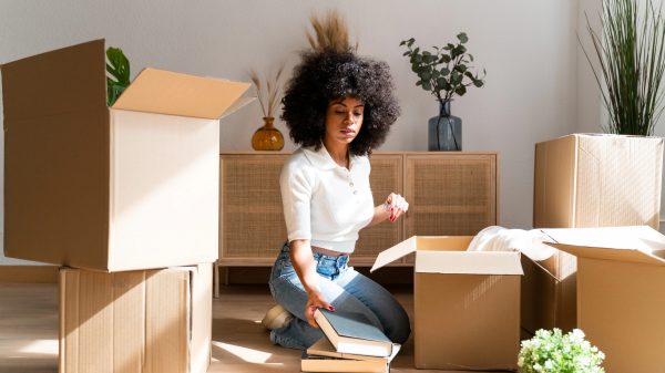 Vrouw op de grond, tussen de verhuisdozen, vers van de woningmarkt