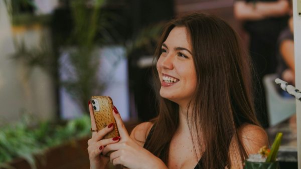 Foto van een vrouw met een telefoon in haar hand | Tikkie Te Veel