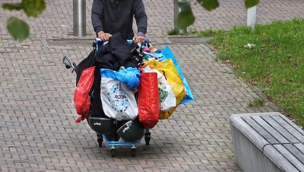 dakloze met winkelwagen vol tassen