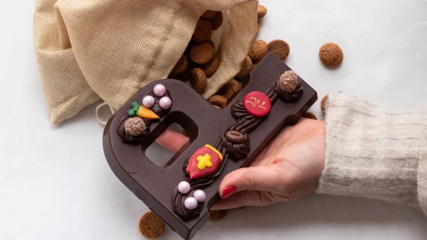 Vrouw heeft chocoladeletter in de hand - Pakjesavond sinterklaasverhalen