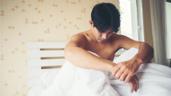 Man baalt op bed van het death-grip syndrome